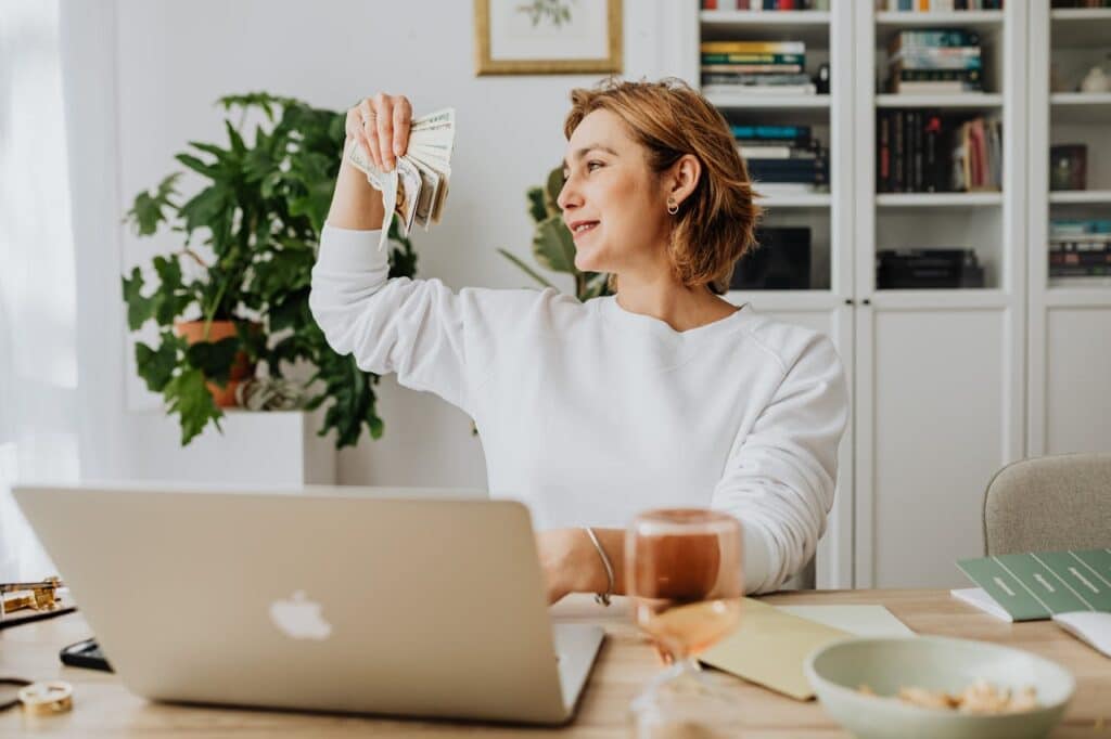 Woman organizing cash at her desk from small savings that compound over time.