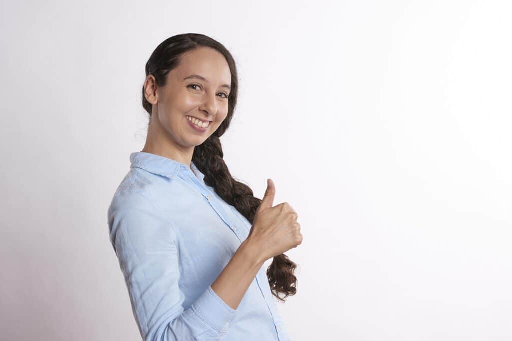 happy person in blue shirt giving a thumbs up